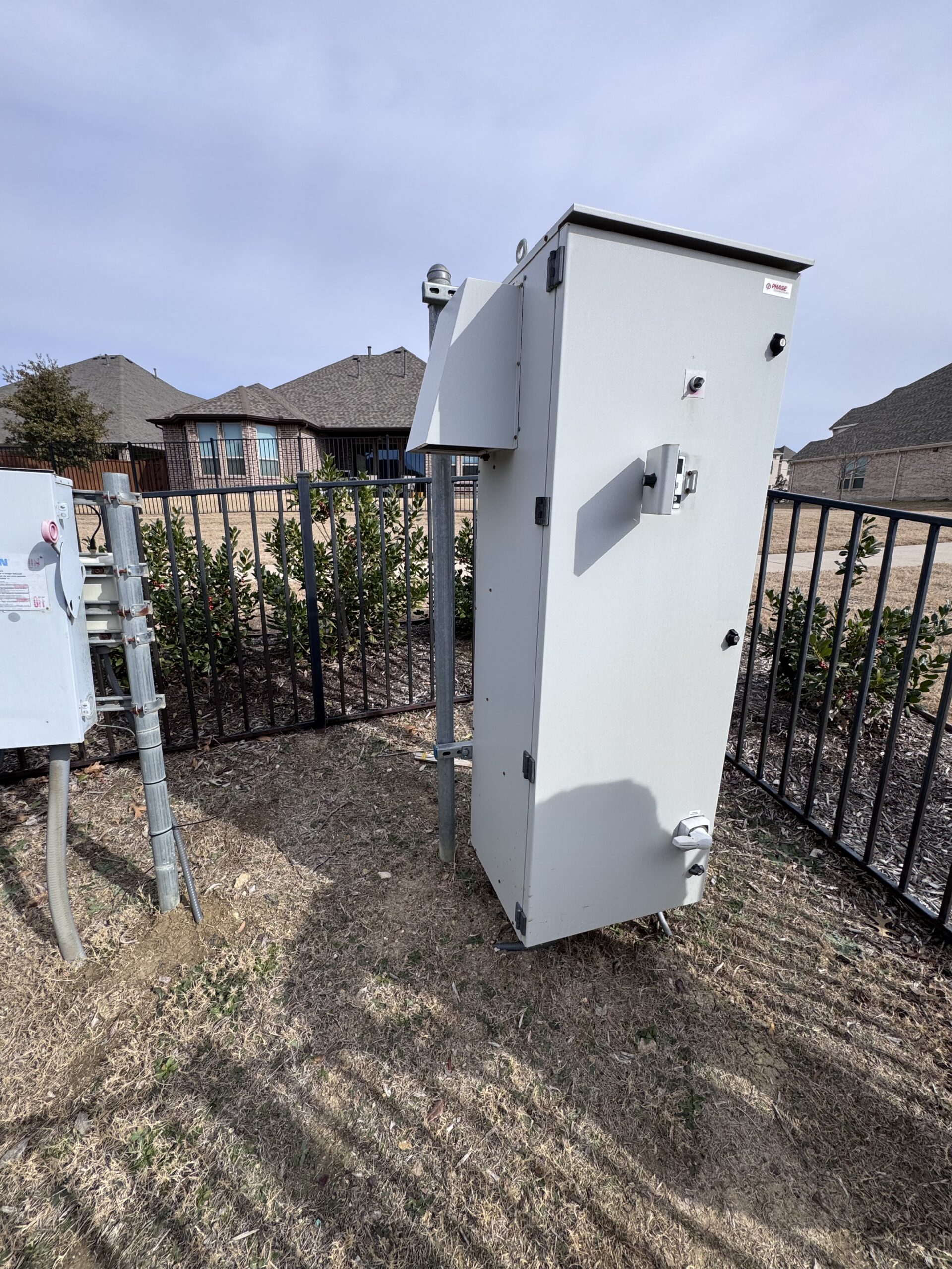 Outdoor well control cabinet installed near residential homes