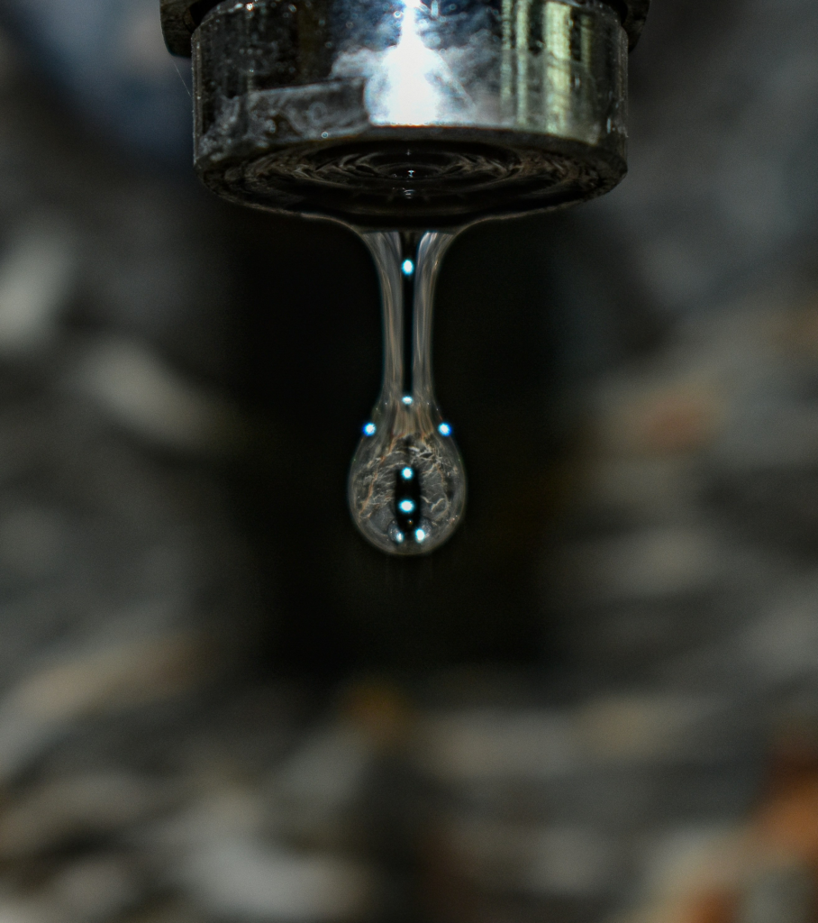 Close-up of clean water droplet falling from faucet